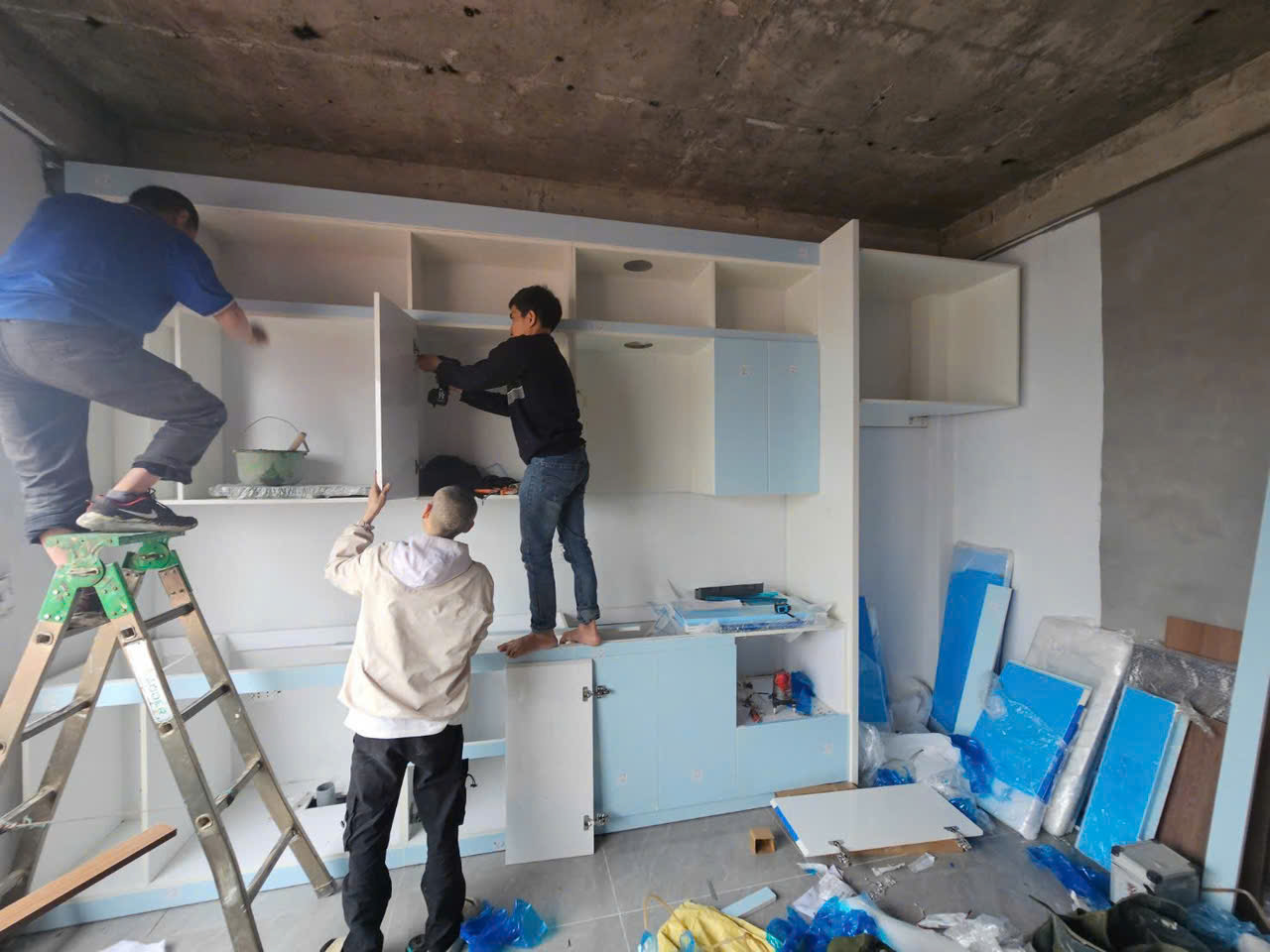 Đội thi công đang lắp ráp hệ tủ treo và tủ dưới tại công trình