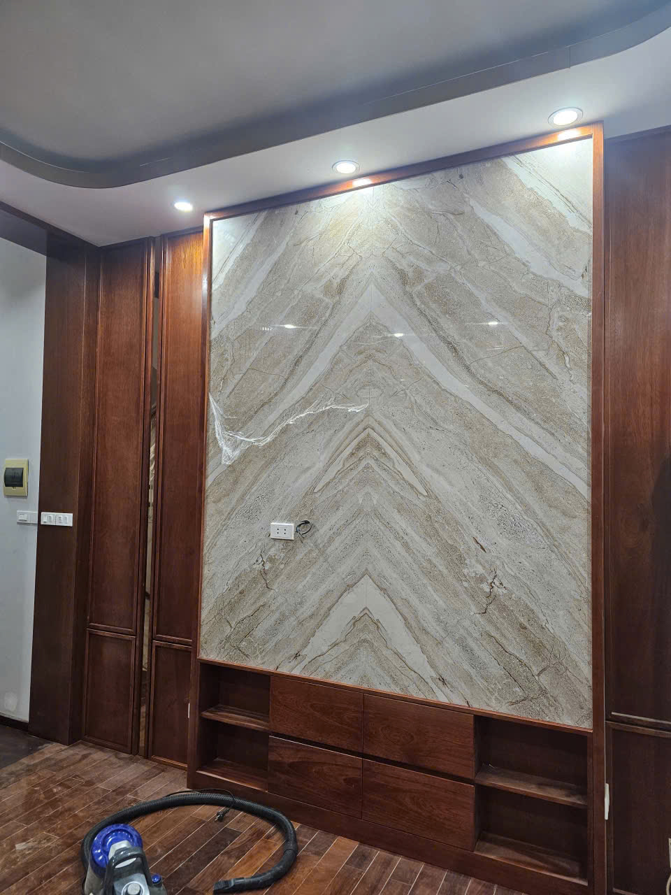 Mảng vách đá trang trí đang hoàn thiện với hệ tủ chân tường bên dưới